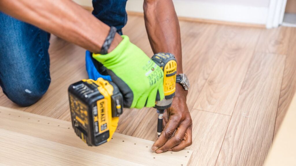 homem usando furadeira e parafusadeira amarela dewalt
