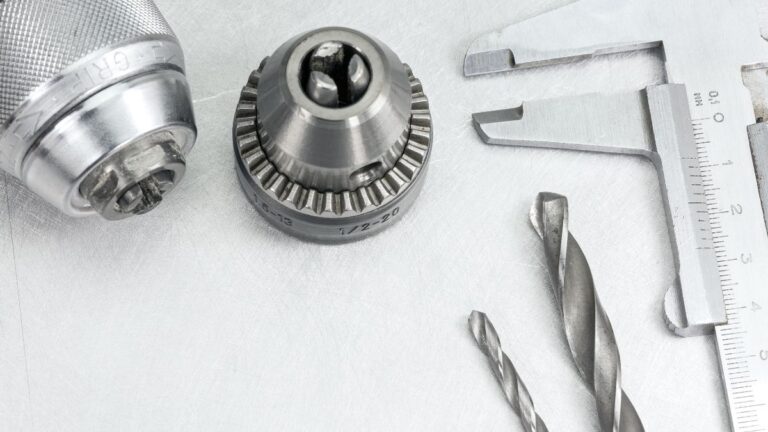 mandril de furadeira ao lado de brocas