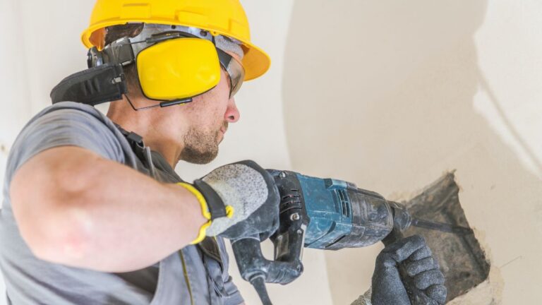 homem usando martelete na parede
